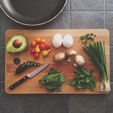 Chopping board with vegetables and sharp knife