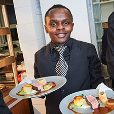 Hospitality student serving plates of food