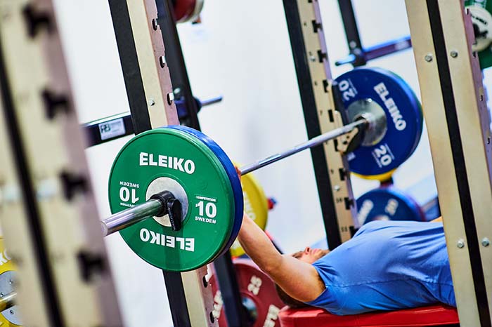 Student pressing chest weight