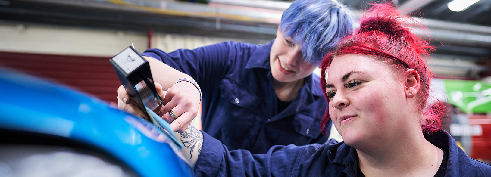 two students working on a car in the workshop