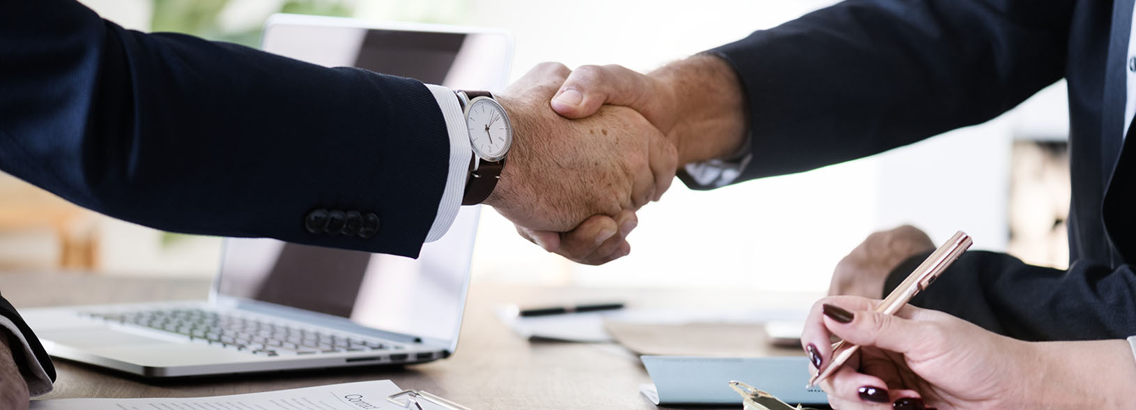 Two people shaking hands to secure a business deal