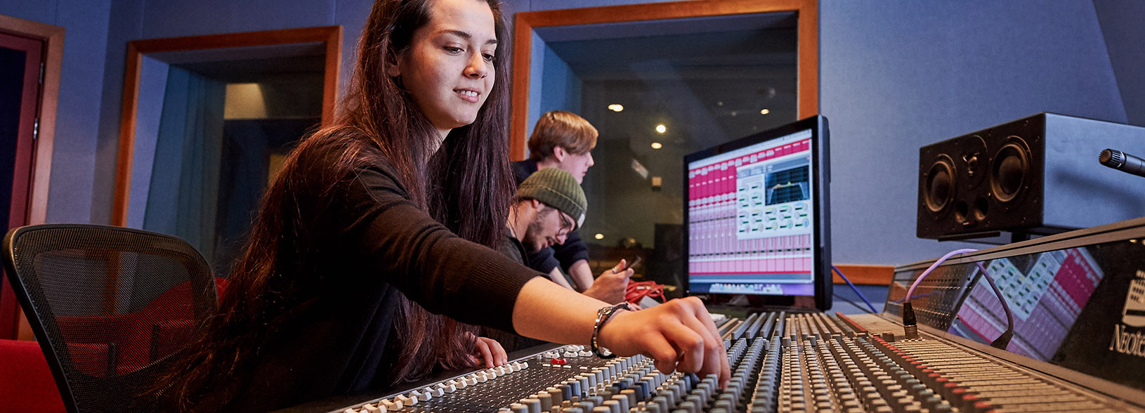 Audio engineering students at sound desk in studio