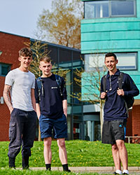 Three students on campus, outside Webster building