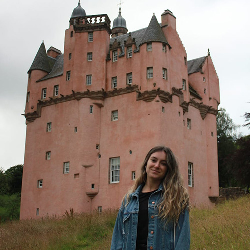 laura standing outside a castle