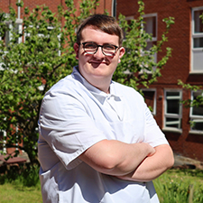 James in a white shirt in the college garden