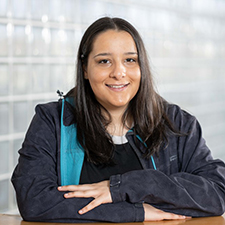 lara sitting with her arms folded in a jacket