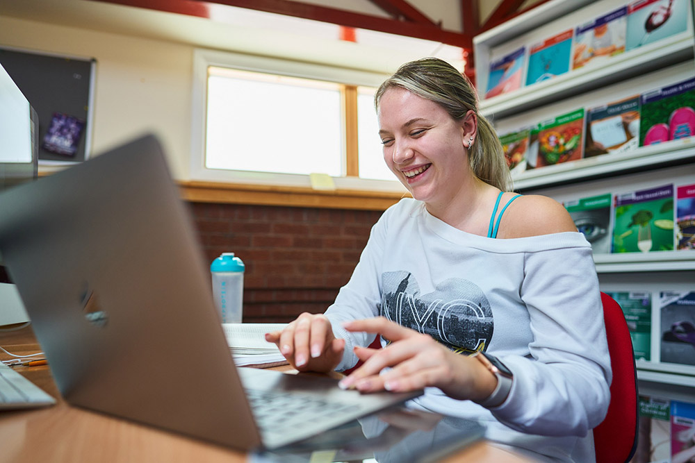 Student using her laptop in the library