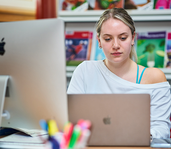 student working on laptop in library