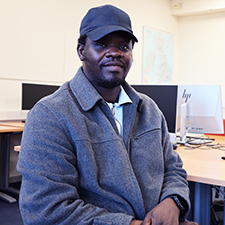 olushola sitting in a classroom with a cap on