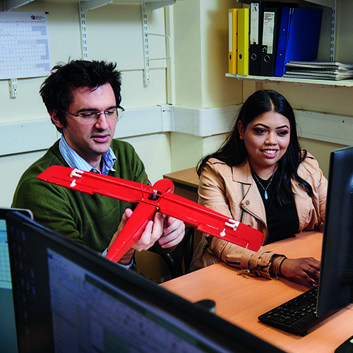 two aviation students in a classroom with a model plane