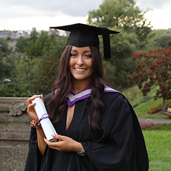Kaytie in her graduation robes holding a scroll