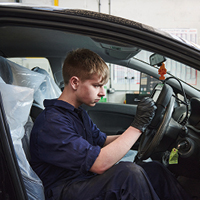 student using diagnostic equipment on a car