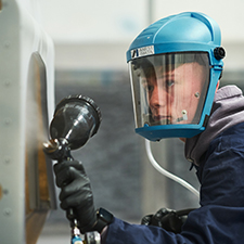 student spraying a car