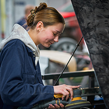 student looking under a car bonnet