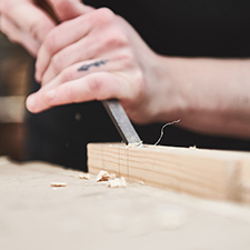 student using a tool to chip wood