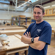 chris standing in the joinery workshop on campus
