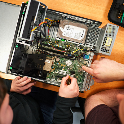 close up of students working on the inside of a computer