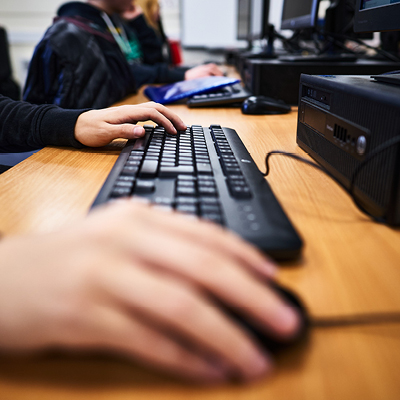 close up of hands on a keyboard and mouse