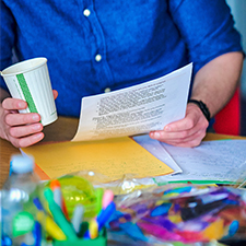 Male student holding coffee and paper