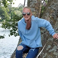 courtney climbing a tree wearing sunglasses