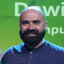 Daniel on stage with a green background behind him