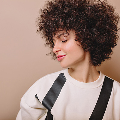 woman with brown wavy hair looking away from the camera