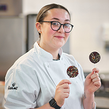 emma in her chef whites holding chocolate