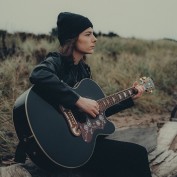 Student playing guitar outside