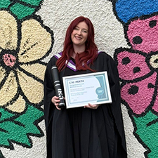 melissa standing holding her graduation certificate