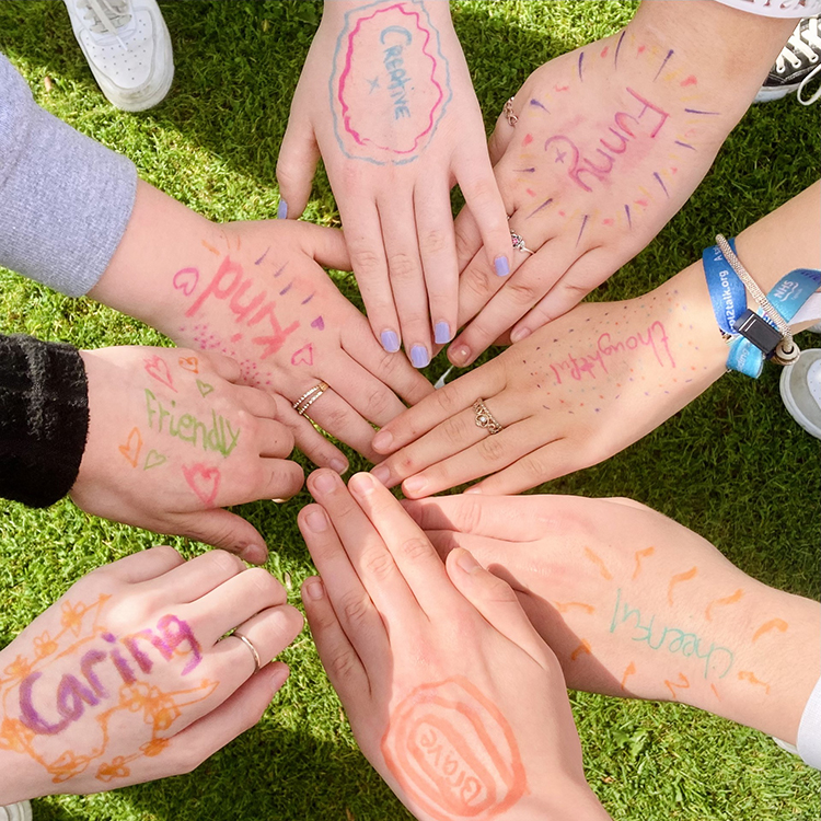 students holding their hands together