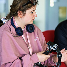 student in a pink tracksuit playing a tambourine