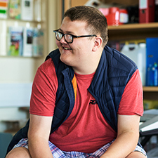 student in a red tshirt and navy gilet