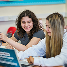 student working on a laptop in a classroom