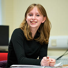 student sitting smiling in a classroom