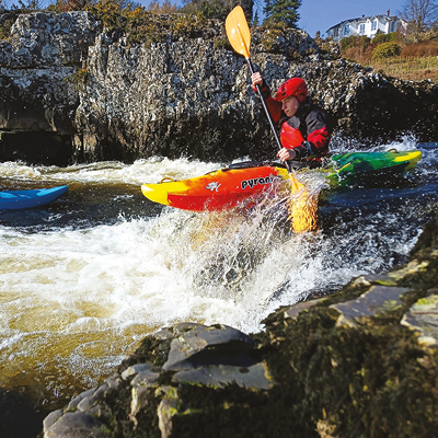 student paddling a kayak on a white water river student paddling a kayak on a white water river